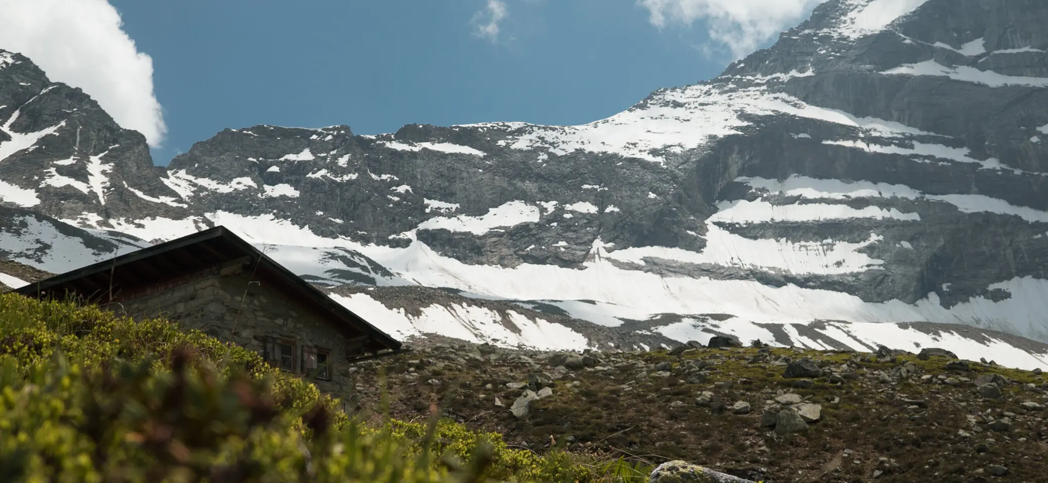 Schneebedeckte Berge, eine Hütte im Vordergrund | © DAV/Marcel Dambon